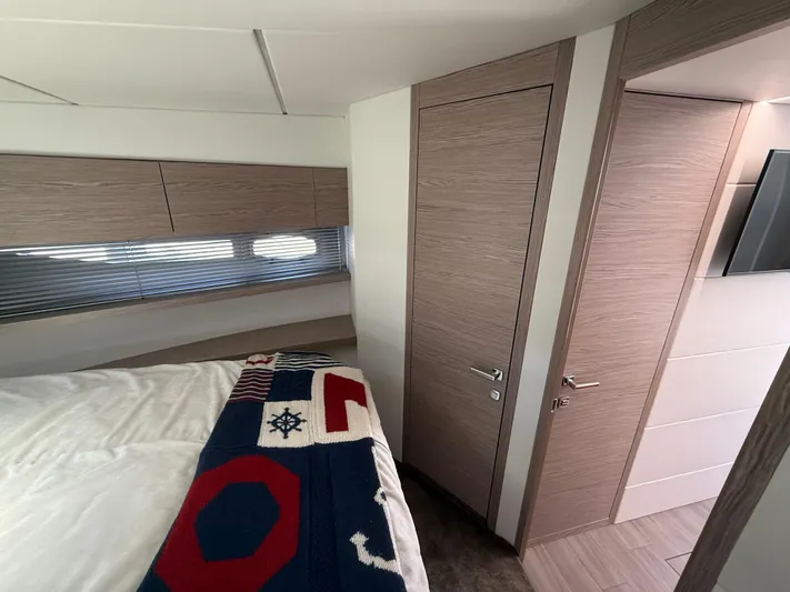  Yacht Photos Pics 2023 Rio Yachts SPORT COUPE interior cabin with modern wood finish and nautical-themed bedding.