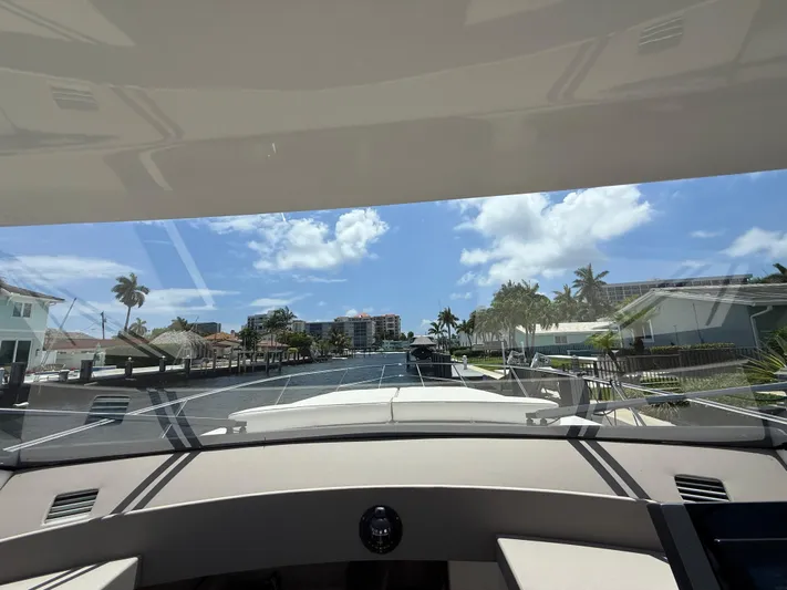  Yacht Photos Pics View from 2023 Rio Yachts SPORT COUPE, navigating a sunny canal with palm trees.