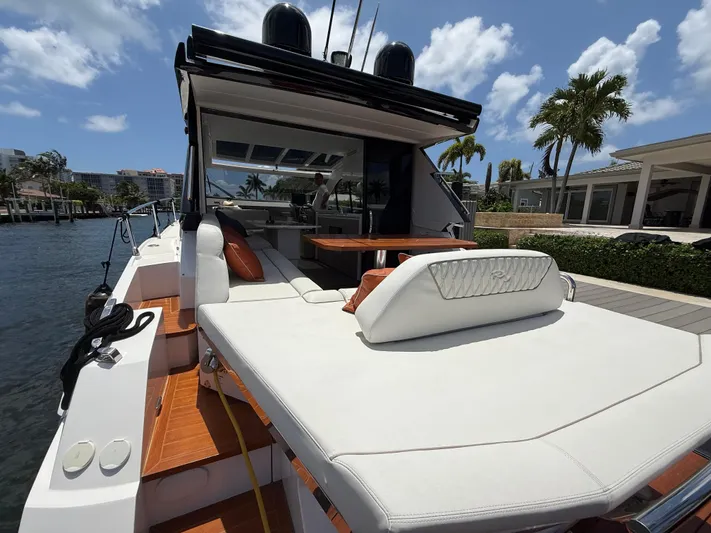  Yacht Photos Pics 2023 Rio Yachts SPORT COUPE with luxurious deck seating, docked by waterfront homes.