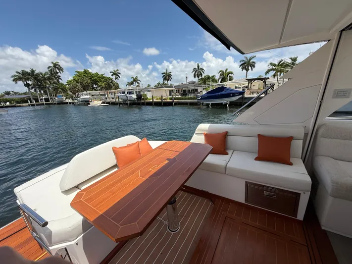  Yacht Photos Pics 2023 Rio Yachts SPORT COUPE deck with seating, wooden table, and waterfront view.