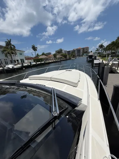  Yacht Photos Pics 2023 Rio Yachts SPORT COUPE docked in a sunny marina, surrounded by palm trees.