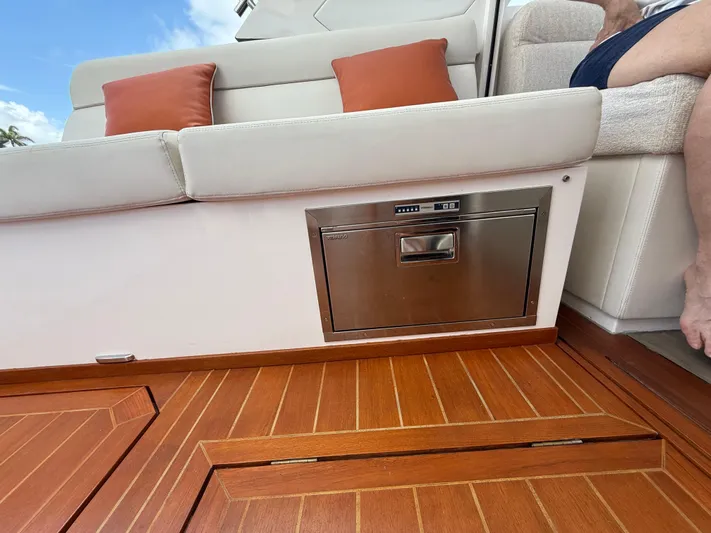  Yacht Photos Pics 2023 Rio Yachts SPORT COUPE interior with white seating, orange cushions, and wooden flooring.