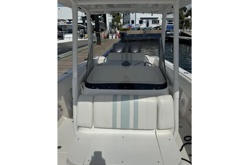  Yacht Photos Pics 2005 Intrepid 323 Cuddy boat interior with white seating and helm, docked at marina.