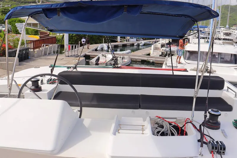 Libertas Ds Yacht Photos Pics 2019 Lagoon 450 F catamaran helm with blue canopy at marina dock.