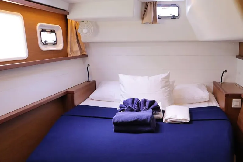 Libertas Ds Yacht Photos Pics Cozy cabin interior of 2019 Lagoon 450 F yacht with neatly arranged bed and porthole windows.