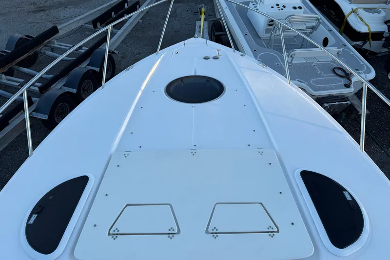  Yacht Photos Pics 2019 Regal 33 OBX boat deck with railings and hatch, docked beside trailers.