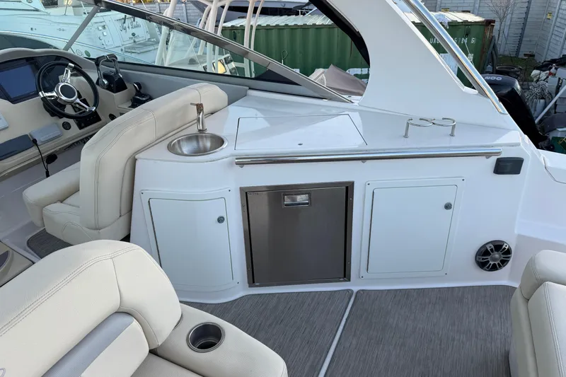  Yacht Photos Pics 2019 Regal 33 OBX boat interior with helm, sink, and seating area.