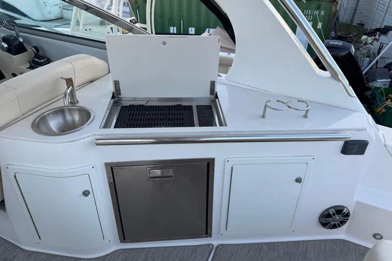  Yacht Photos Pics 2019 Regal 33 OBX boat kitchenette with sink, grill, and storage cabinets.