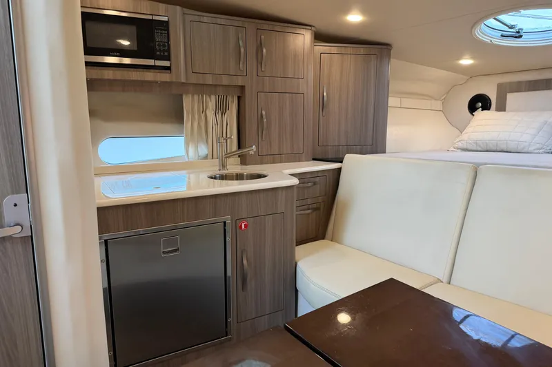  Yacht Photos Pics 2019 Regal 33 OBX cabin interior with kitchenette, seating, and bed.