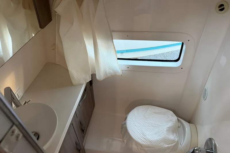  Yacht Photos Pics 2019 Regal 33 OBX boat bathroom with sink, toilet, and window.