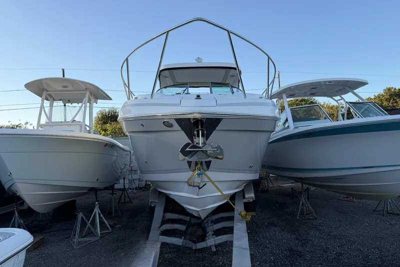  Yacht Photos Pics 2019 Regal 33 OBX boat on stands, flanked by two other boats, in a storage yard.