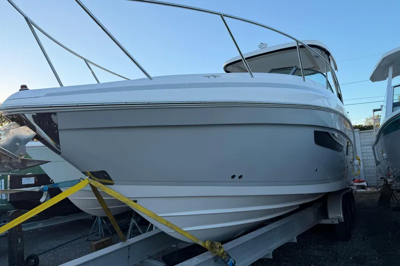  Yacht Photos Pics 2019 Regal 33 OBX boat on trailer, secured with straps, side view.
