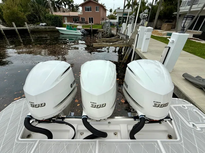  Yacht Photos Pics Triple Yamaha 300 outboard engines on a 2021 Regal 38 SAV boat docked by a canal.