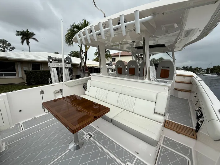  Yacht Photos Pics 2021 Regal 38 SAV boat with elegant seating and wooden table on deck.