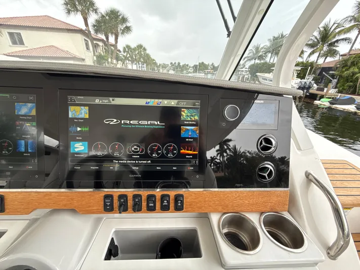  Yacht Photos Pics 2021 Regal 38 SAV dashboard with touchscreen display and controls, docked near palm trees.