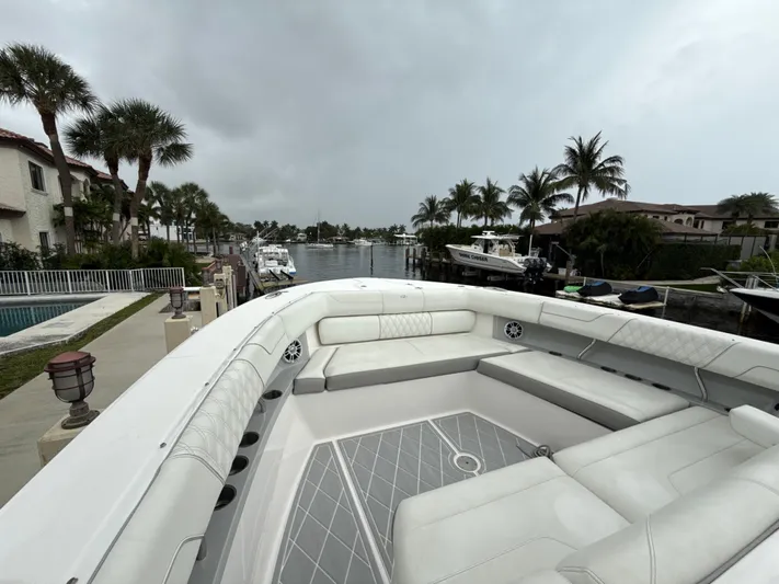  Yacht Photos Pics 2021 Regal 38 SAV boat with spacious seating, docked near palm trees and waterfront homes.