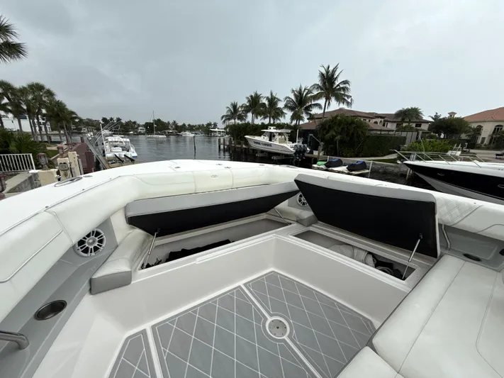  Yacht Photos Pics 2021 Regal 38 SAV boat interior with open storage, docked near palm trees and waterfront homes.
