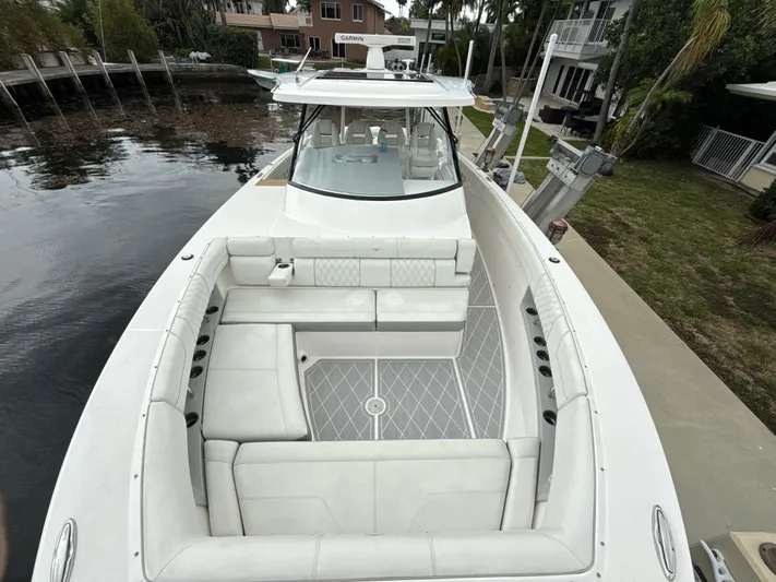  Yacht Photos Pics 2021 Regal 38 SAV boat with spacious seating, docked by a waterfront property.