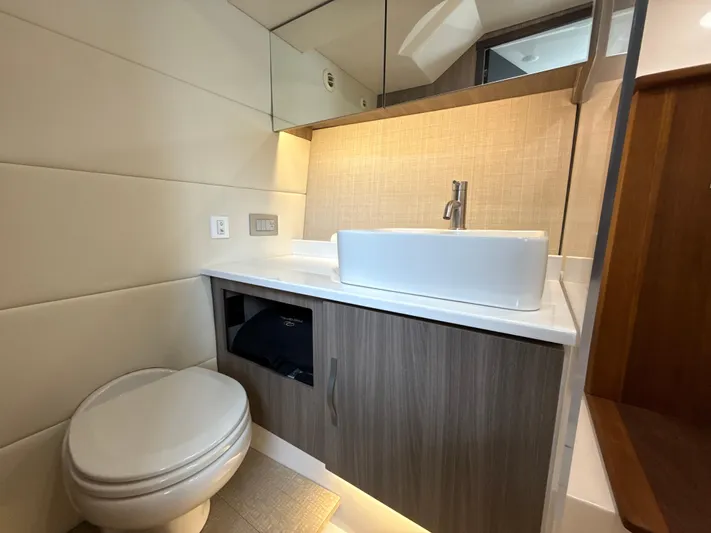  Yacht Photos Pics 2021 Regal 38 SAV bathroom with modern sink, toilet, and wood cabinetry.