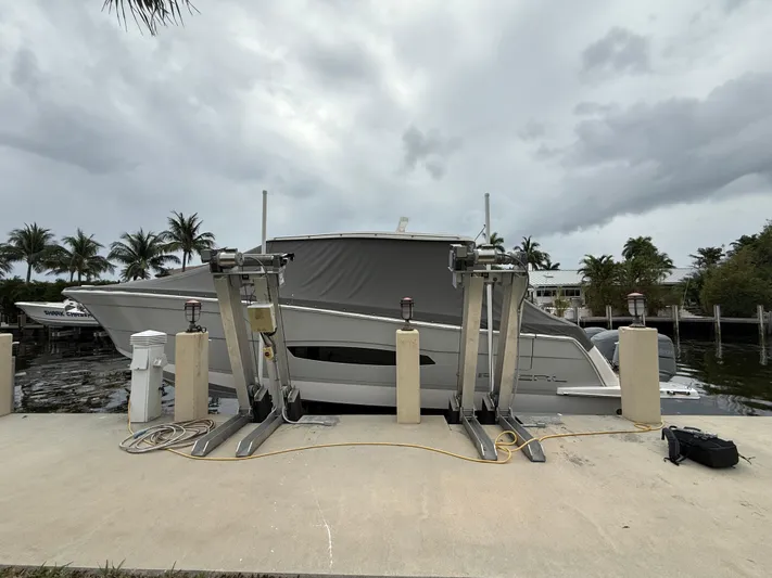  Yacht Photos Pics 2021 Regal 38 SAV boat docked with overcast sky and palm trees in the background.