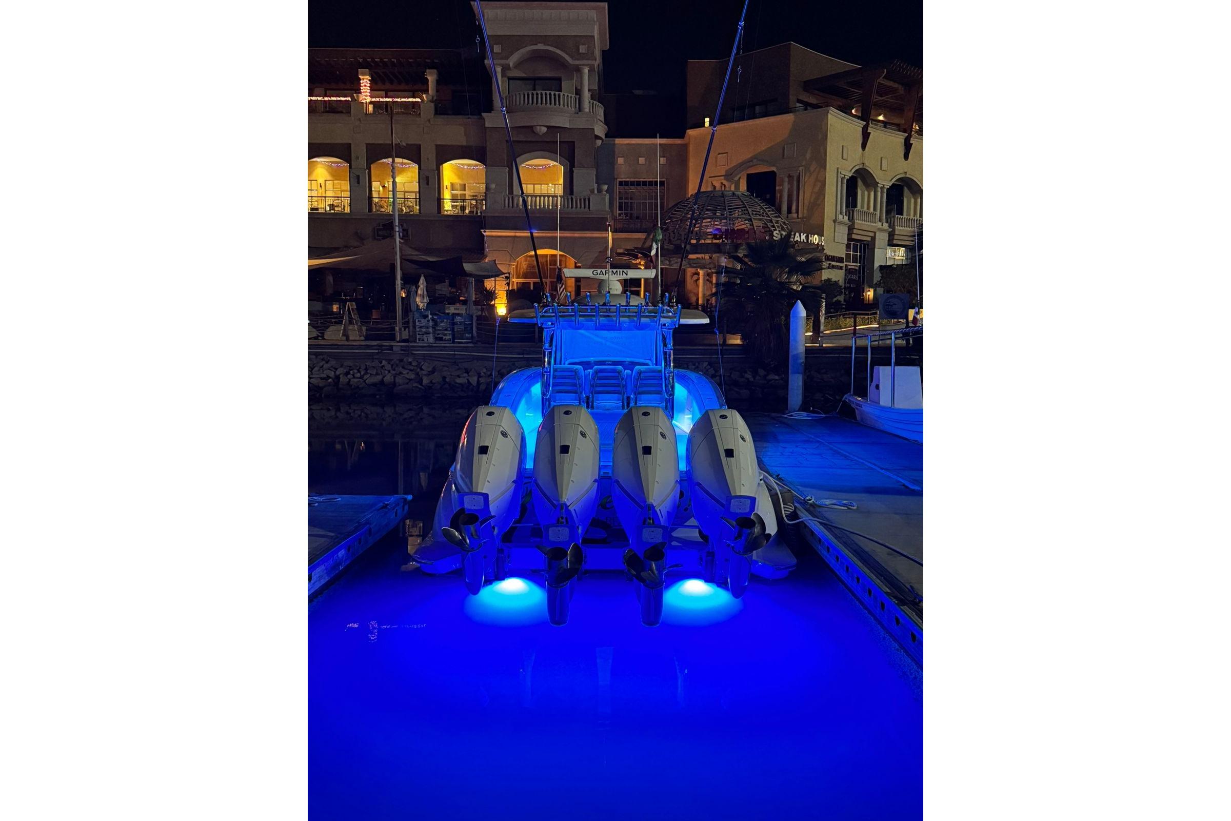 2024 Mag Bay 43 CC boat with illuminated blue underwater lights at night.