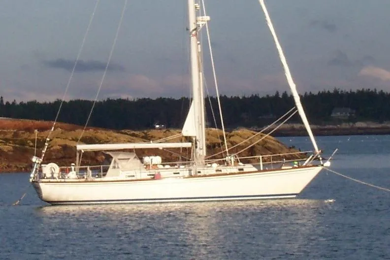 September Morn Yacht Photos Pics 1986 Little Harbor AFt Cockpit K/CB Sloop sailing near rocky shoreline at sunset.