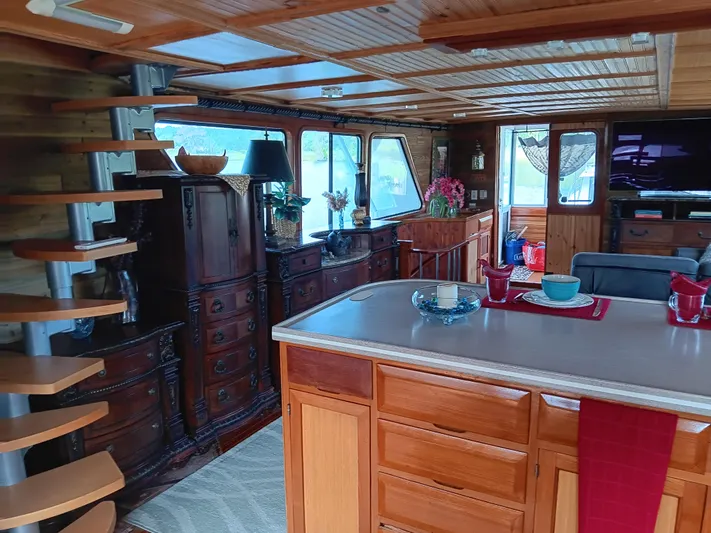 Elizabeth Yacht Photos Pics Interior of 1989 DeFever 57 POC Motor Yacht with wooden decor and spiral staircase.