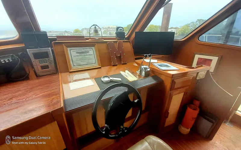 Elizabeth Yacht Photos Pics 1989 DeFever 57 POC Motor Yacht helm with steering wheel, navigation equipment, and wooden dashboard.
