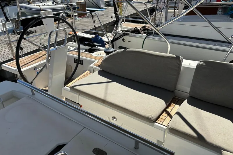  Yacht Photos Pics Cockpit of 2019 Beneteau Oceanis 51.1 sailboat with cushioned seating and steering wheel.