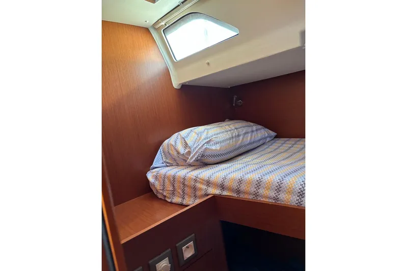  Yacht Photos Pics Cozy cabin interior of 2019 Beneteau Oceanis 51.1 with a neatly made bed.