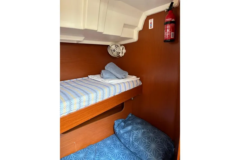  Yacht Photos Pics Cozy cabin interior of 2019 Beneteau Oceanis 51.1 with bunk beds and fire extinguisher.