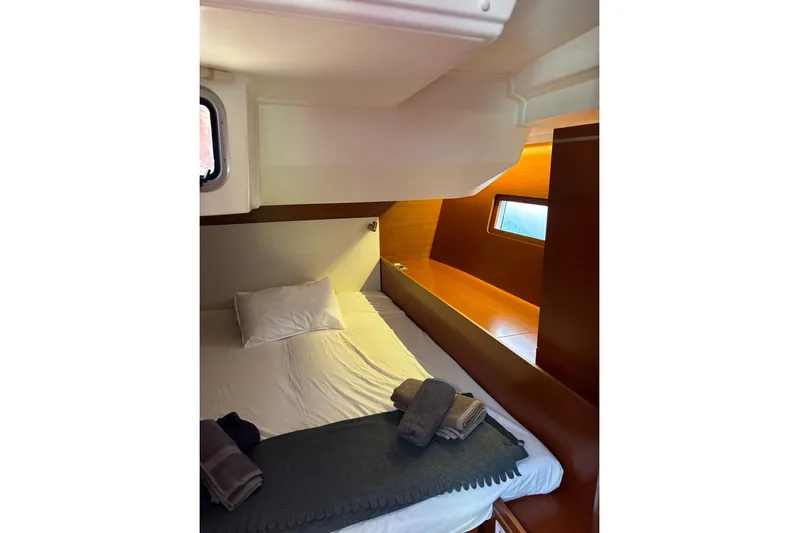  Yacht Photos Pics Cozy cabin interior of 2019 Beneteau Oceanis 51.1 yacht with bed and window.
