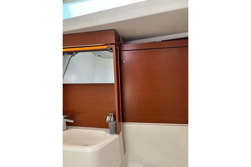  Yacht Photos Pics Bathroom interior of 2019 Beneteau Oceanis 51.1 yacht with wooden cabinetry and sink.