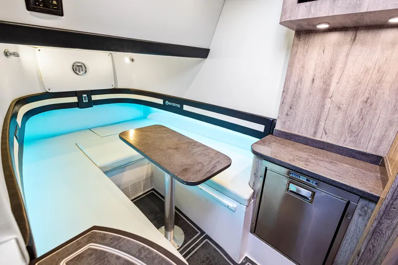  Yacht Photos Pics 2026 Mystic Powerboats M4200 interior with modern seating, table, and kitchenette.