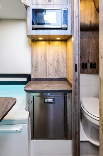  Yacht Photos Pics 2026 Mystic Powerboats M4200 interior with modern kitchenette and compact bathroom.