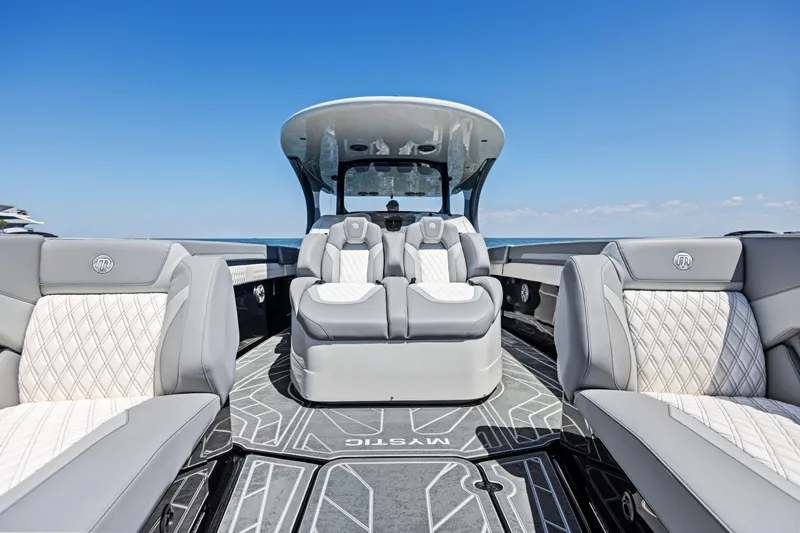  Yacht Photos Pics 2026 Mystic Powerboats M4200 interior with luxurious seating and sleek design under clear blue sky.
