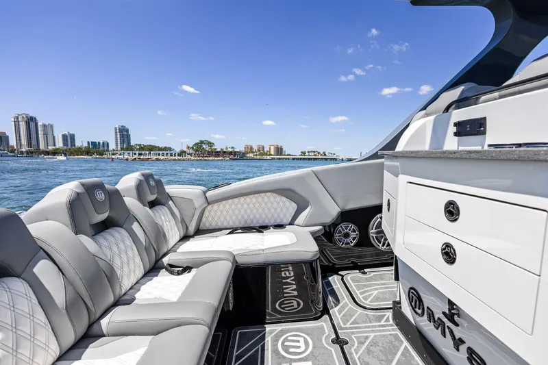  Yacht Photos Pics Luxurious 2026 Mystic Powerboats M4200 interior with plush seating, city skyline in background.