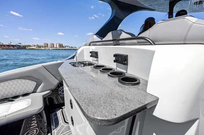  Yacht Photos Pics 2026 Mystic Powerboats M4200 interior with sleek countertop and cup holders on a sunny day.