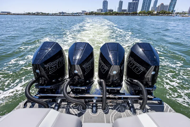 Yacht Photos Pics Four powerful outboard engines on a 2026 Mystic Powerboats M4200, cruising near a city skyline.