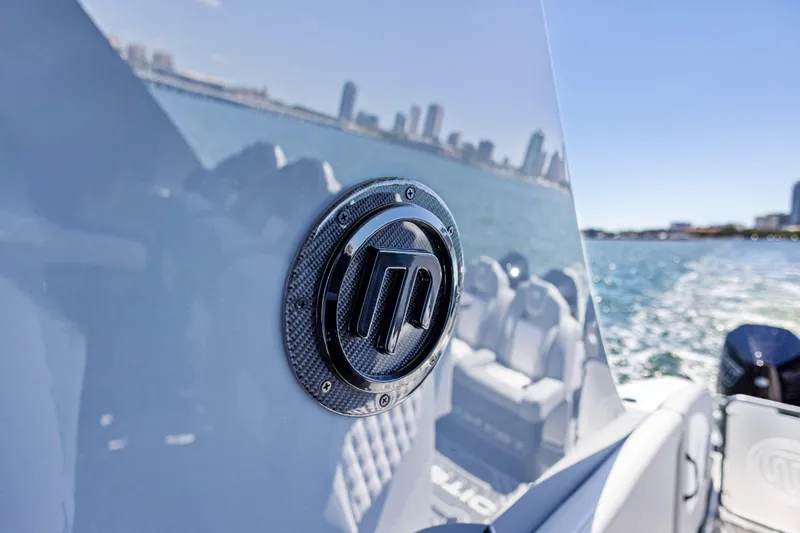  Yacht Photos Pics 2026 Mystic Powerboats M4200 emblem on sleek boat, city skyline in background.