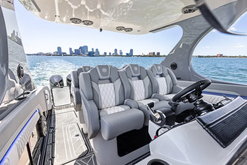  Yacht Photos Pics Luxurious 2026 Mystic Powerboats M4200 interior with plush seating and city skyline view.