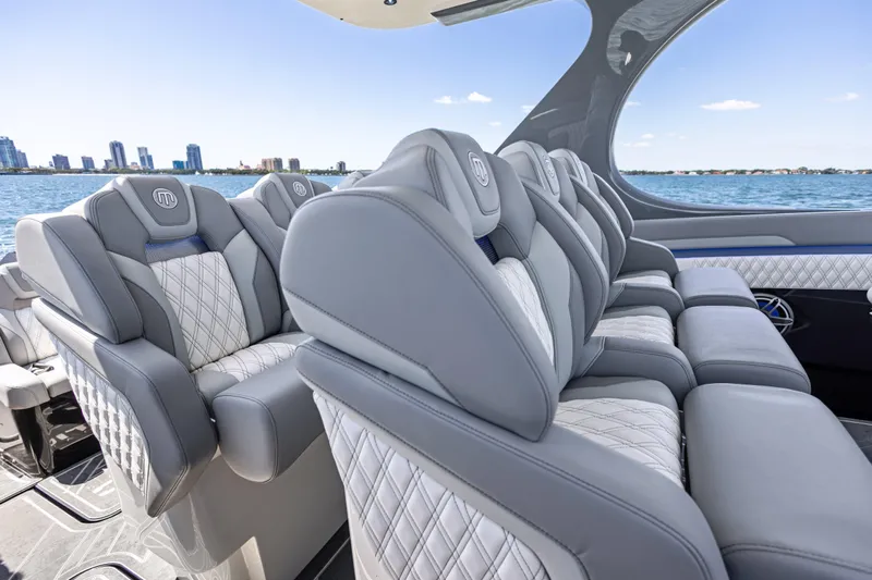  Yacht Photos Pics Luxurious seating on 2026 Mystic Powerboats M4200, with city skyline and ocean view.