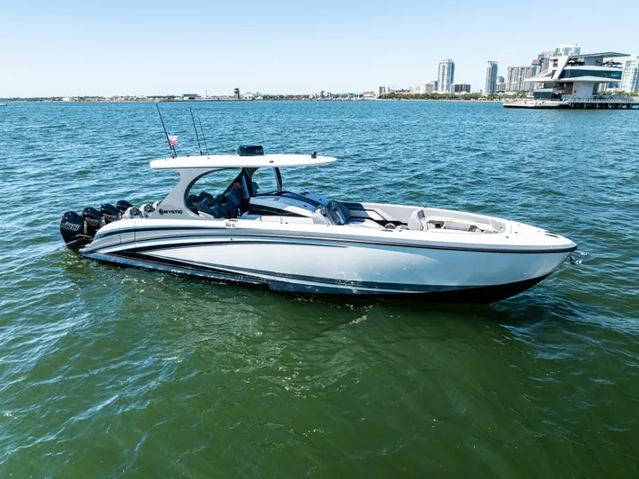  Yacht Photos Pics 2026 Mystic Powerboats M4200 cruising on water near city skyline.