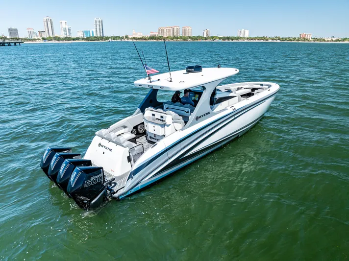 Yacht Photos Pics 2026 Mystic Powerboats M4200 cruising on water with city skyline in background.