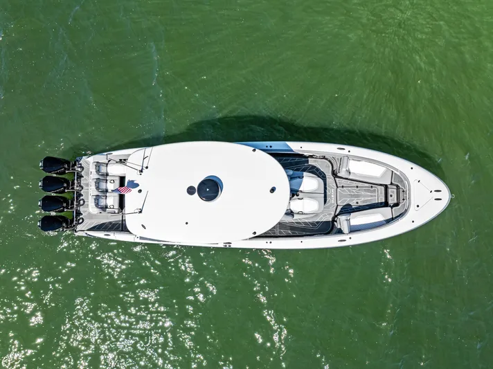  Yacht Photos Pics Top view of 2026 Mystic Powerboats M4200 on green water, showcasing sleek design and powerful engines.