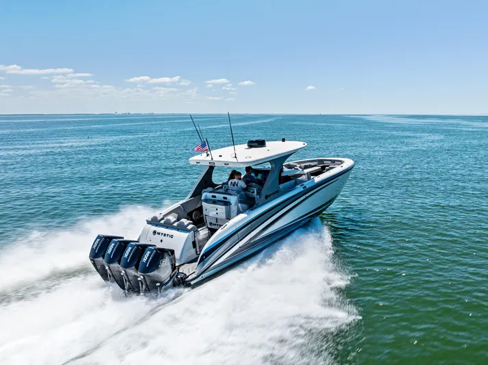 Yacht Photos Pics 2026 Mystic Powerboats M4200 speeding on open water under clear blue skies.
