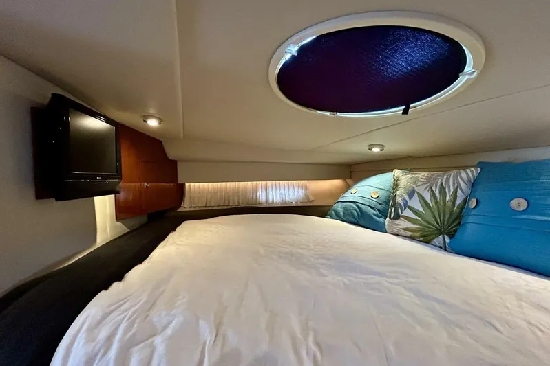  Yacht Photos Pics Cozy cabin interior of 2011 Regal 38 Express yacht with bed, pillows, and TV.