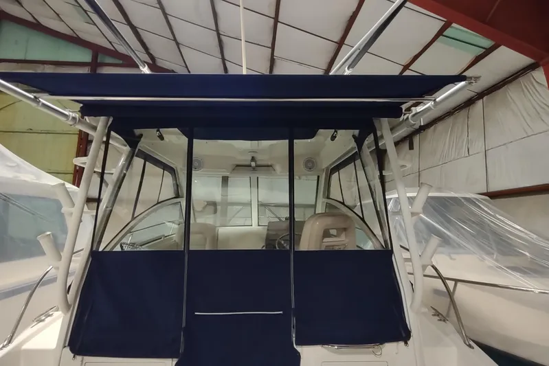  Yacht Photos Pics 2015 Boston Whaler 285 Conquest boat with blue canopy in storage facility.