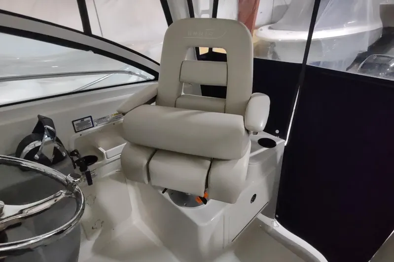 Yacht Photos Pics Captain's chair on 2015 Boston Whaler 285 Conquest boat, featuring comfortable seating and steering wheel.