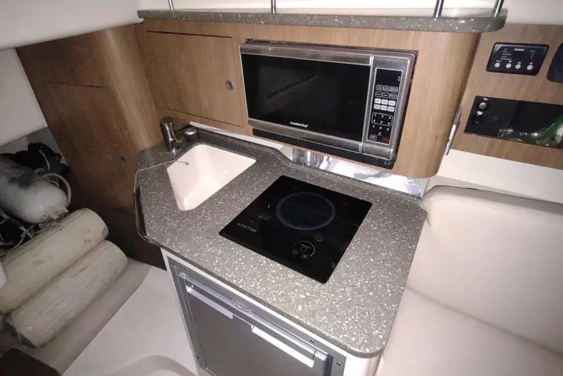  Yacht Photos Pics 2015 Boston Whaler 285 Conquest galley with microwave, sink, and cooktop.